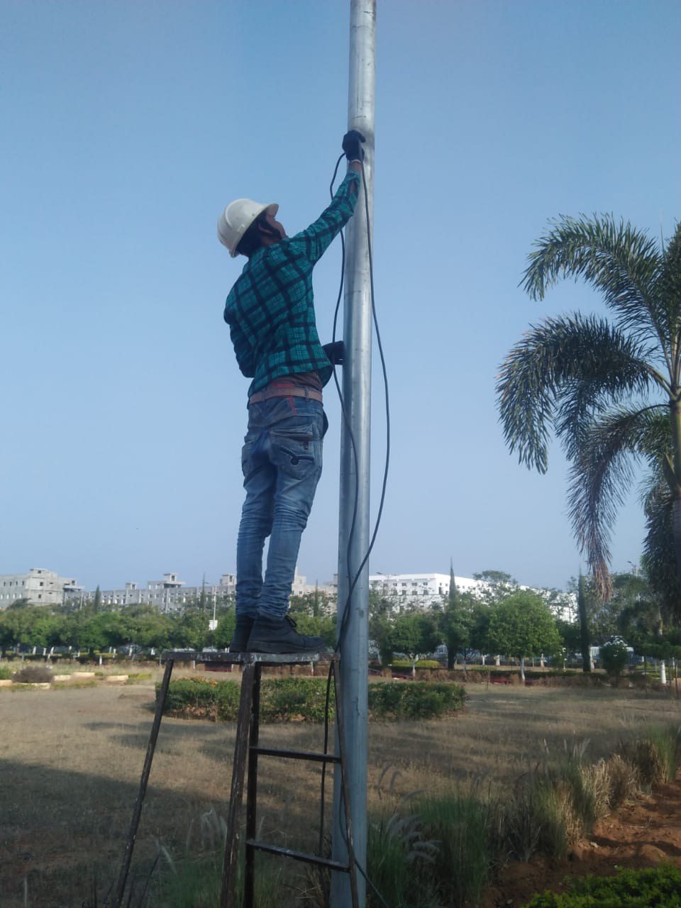 Securizen technician running cable on an outdoor CCTV pole